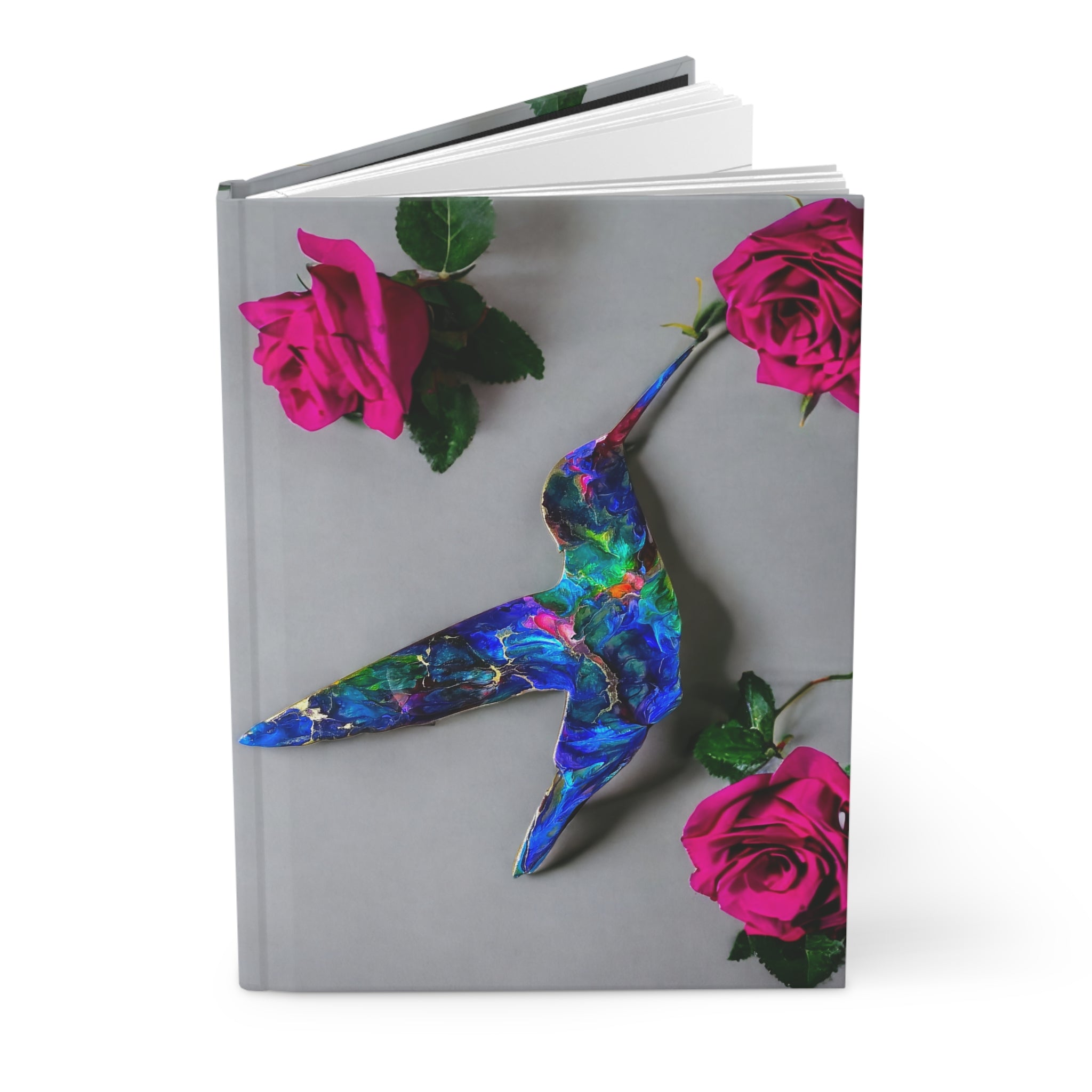 An open view of a lined page journal showcasing the mixed media art of a blue hummingbird, highlighting the handmade resin on wood craftsmanship against a floral backdrop.