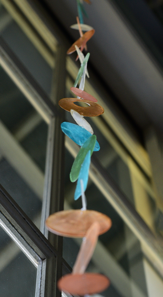 Capiz Shell Strands Patio Garden and Doorway Decoration featuring tropical flowers, showcasing a vibrant mix of turquoise blue, green, apricot, and ivory hues shimmering in the light. Perfect for adding a decorative touch to indoor and outdoor spaces.