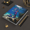 Load image into Gallery viewer, Cover of a stunning hardcover journal featuring a gorgeous blue and pink mermaid design, showcasing a handmade resin on wood art style with beautiful ocean water backdrop.