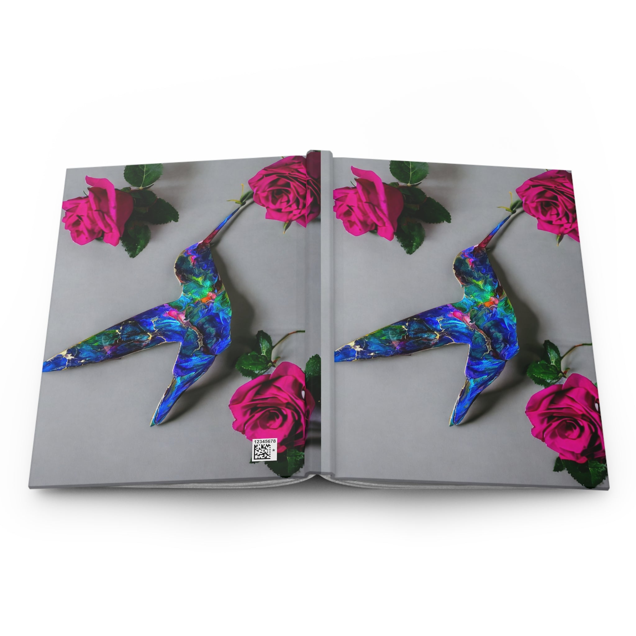 A side perspective of the hardcover journal, illustrating the full wraparound print of a blue hummingbird, a stunning handmade resin on wood art piece paired with pink roses.
