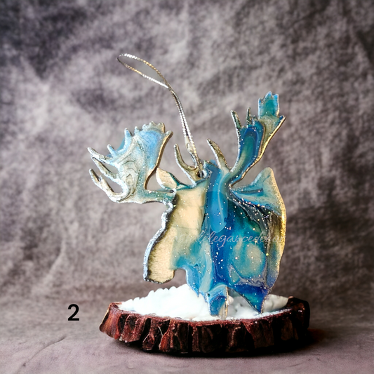 Close-up view of a unique moose head ornament featuring handmade resin on wood, accented with metallic details, making it an ideal cabin-themed decor piece.