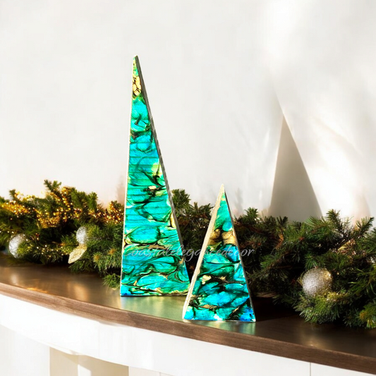 Beachy Blue Contemporary Triangle Christmas Trees in vibrant colors displayed on a table with greenery, showcasing their unique design and metallic gold accents.