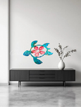 Load image into Gallery viewer, Bright Tropical turquoise turtle with red Hawaiian flowers hanging on a wall above a contemporary black credenza resin on wood handmade.