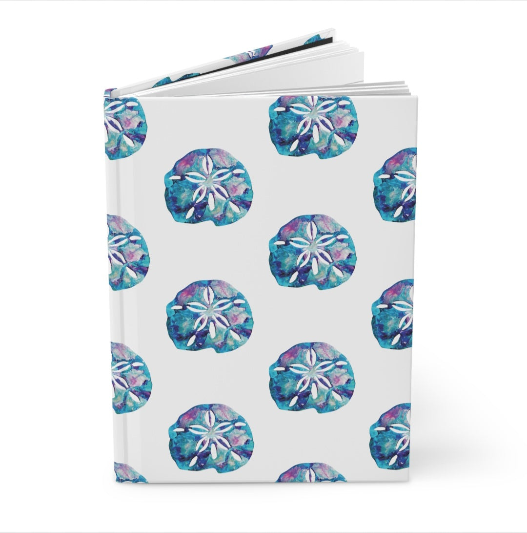 Close-up of the Beautiful Beachy Sand Dollar All Over Print Hardcover Journal, displaying the lined paper and the artistic sand dollar pattern.