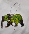 Charger l'image dans la visionneuse de la galerie, Close-up of the Handmade Grizzly Bear Christmas Ornament with Salmon showcasing its colorful resin overlay and metallic accents.
