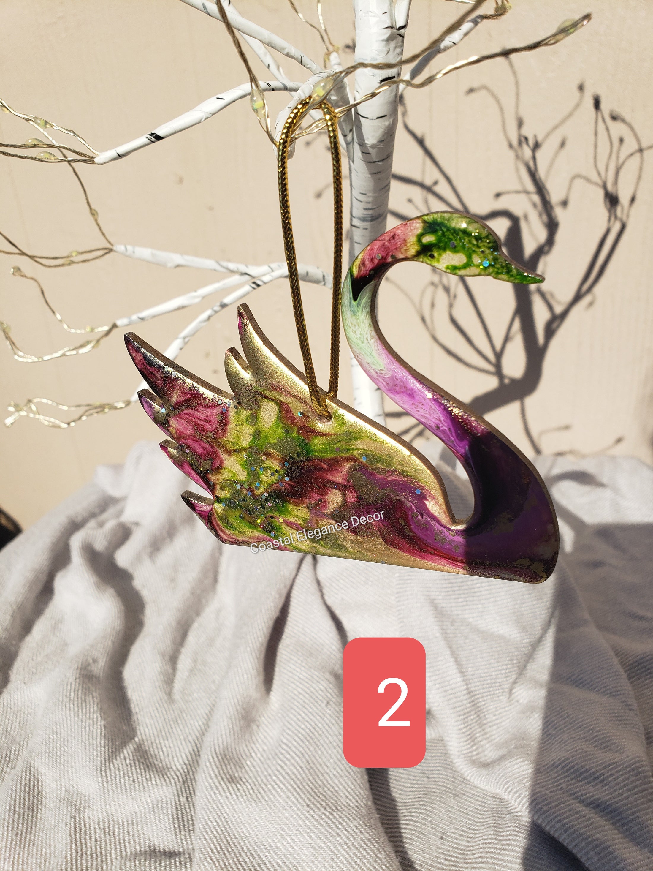 Charming handmade resin on wood swan ornament displaying glittery details, a delightful addition to your Christmas tree.