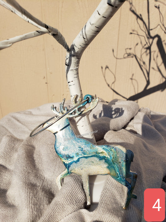 Close-up of a handmade resin on wood reindeer ornament featuring unique fluid art patterns, ideal for holiday decor.