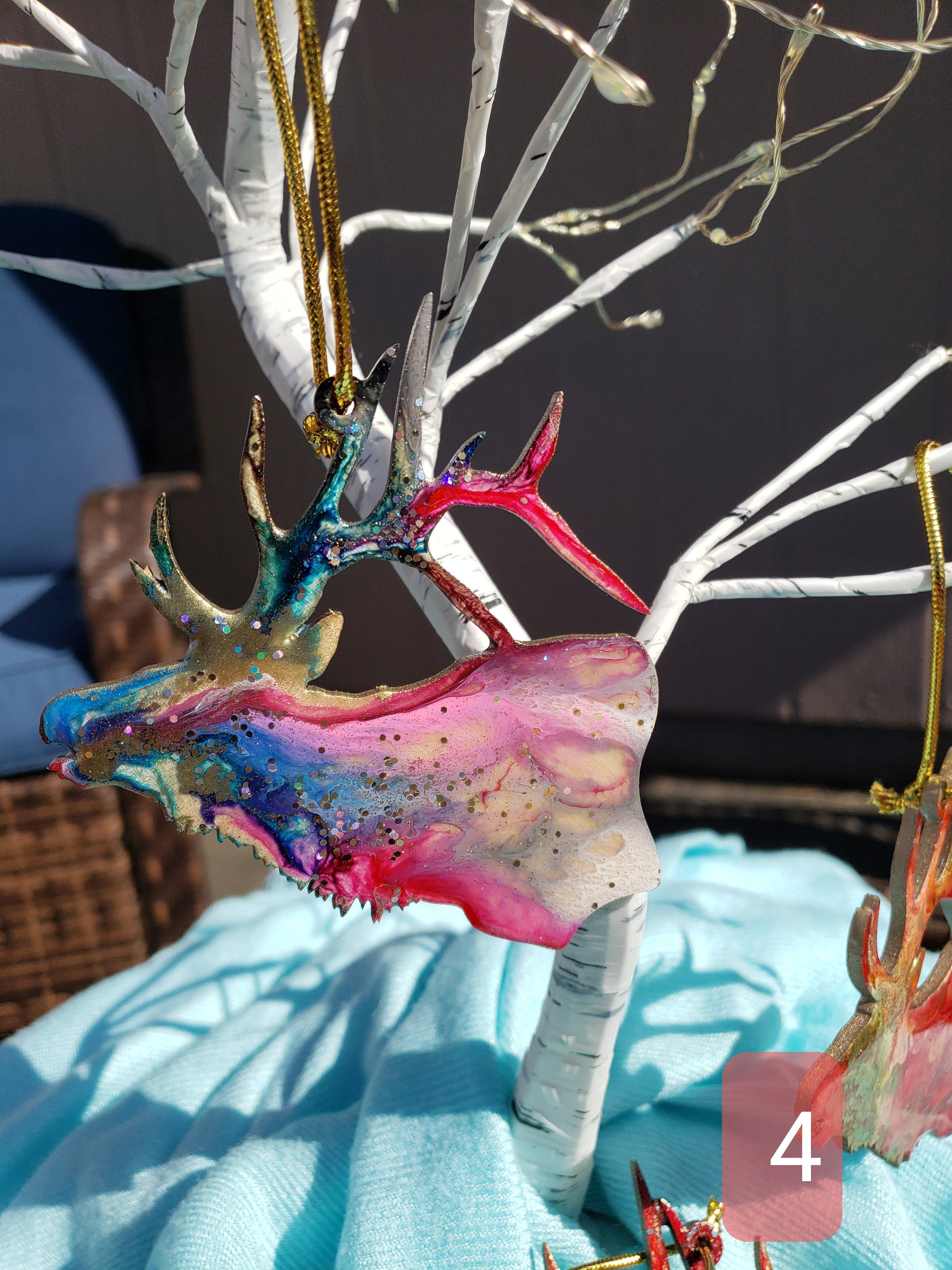 Unique handmade resin on wood elk ornament, highlighting the fluid art technique and colorful accents, suitable for holiday decor.