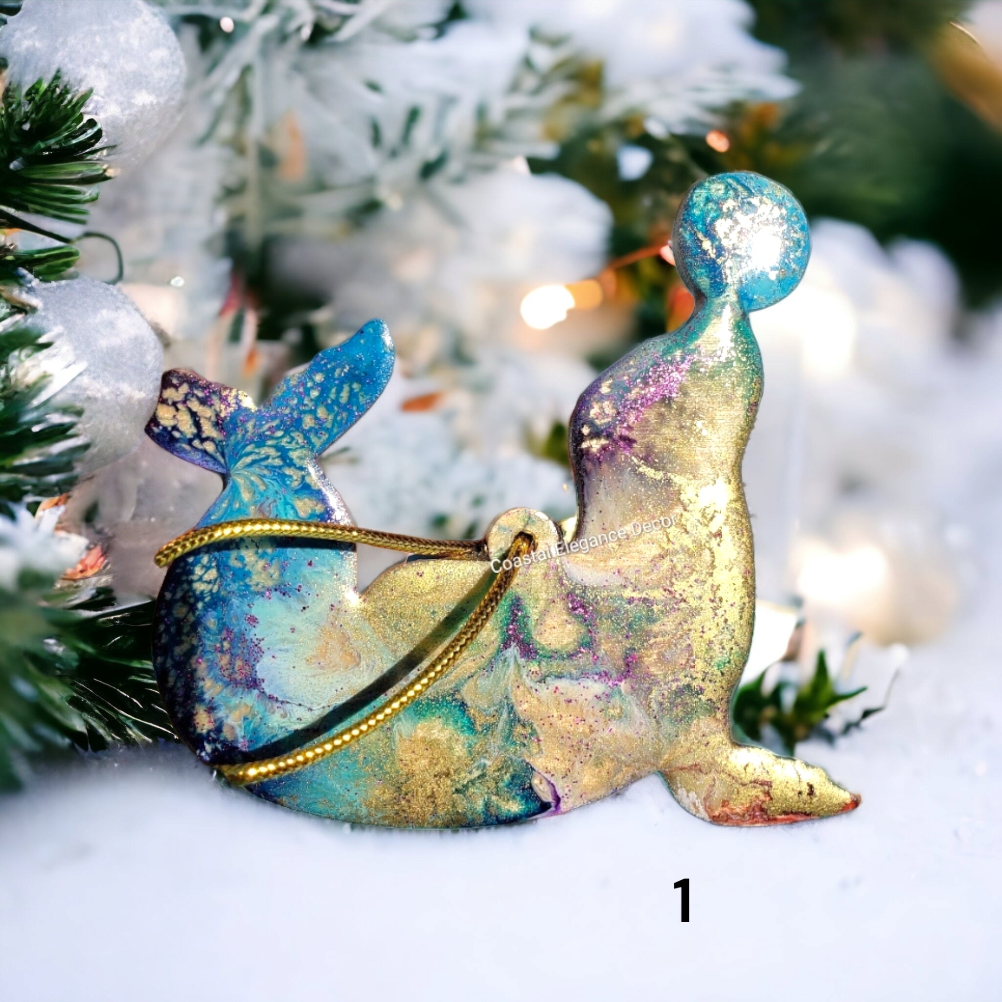 Close-up of a playful seal ornament made from handmade resin on wood, showcasing colorful details and a ball.
