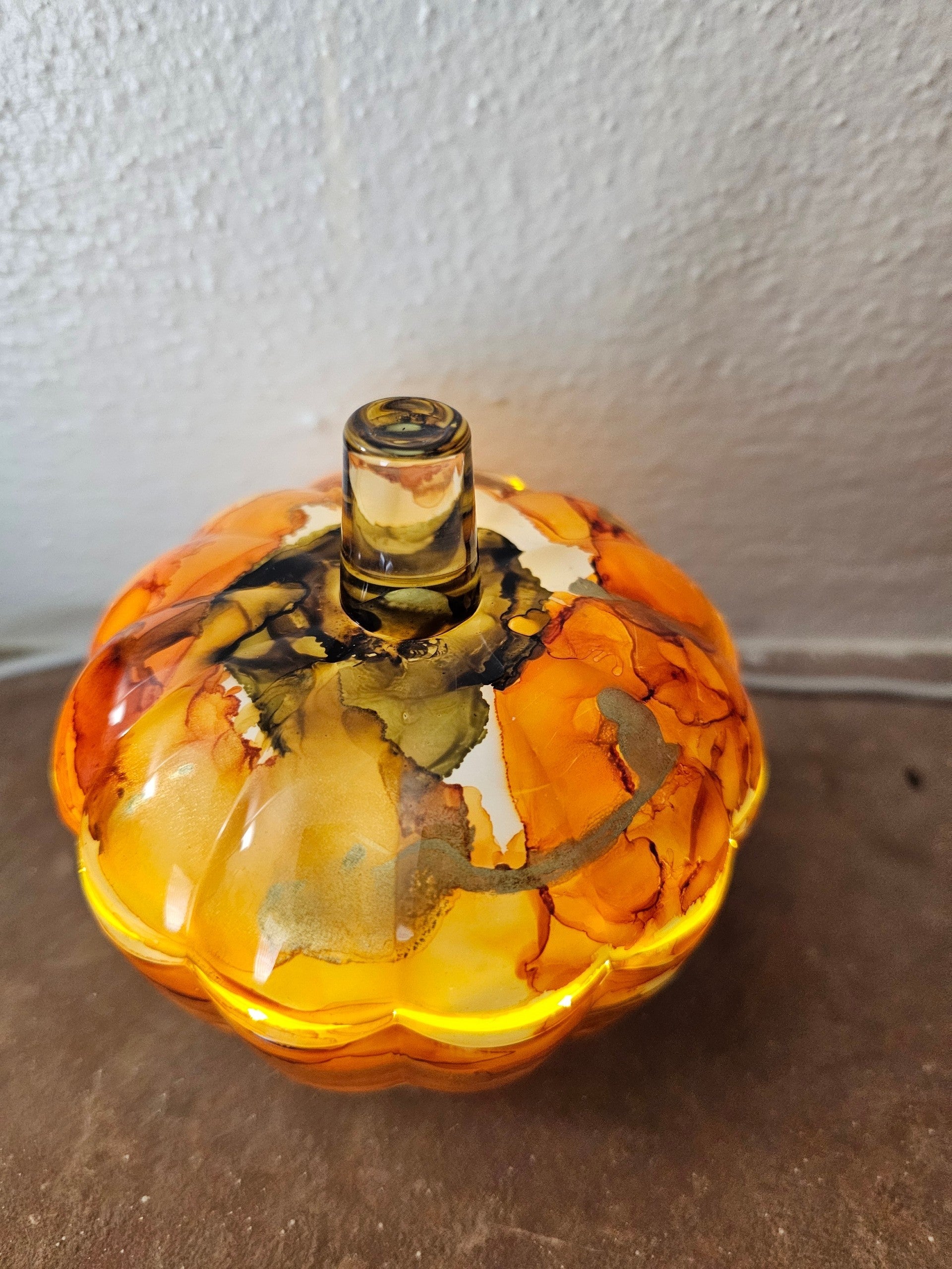 Coastal Elegance Decor handcrafted glass pumpkin dish with amber, orange, and obsidian ink-style swirls and lid.