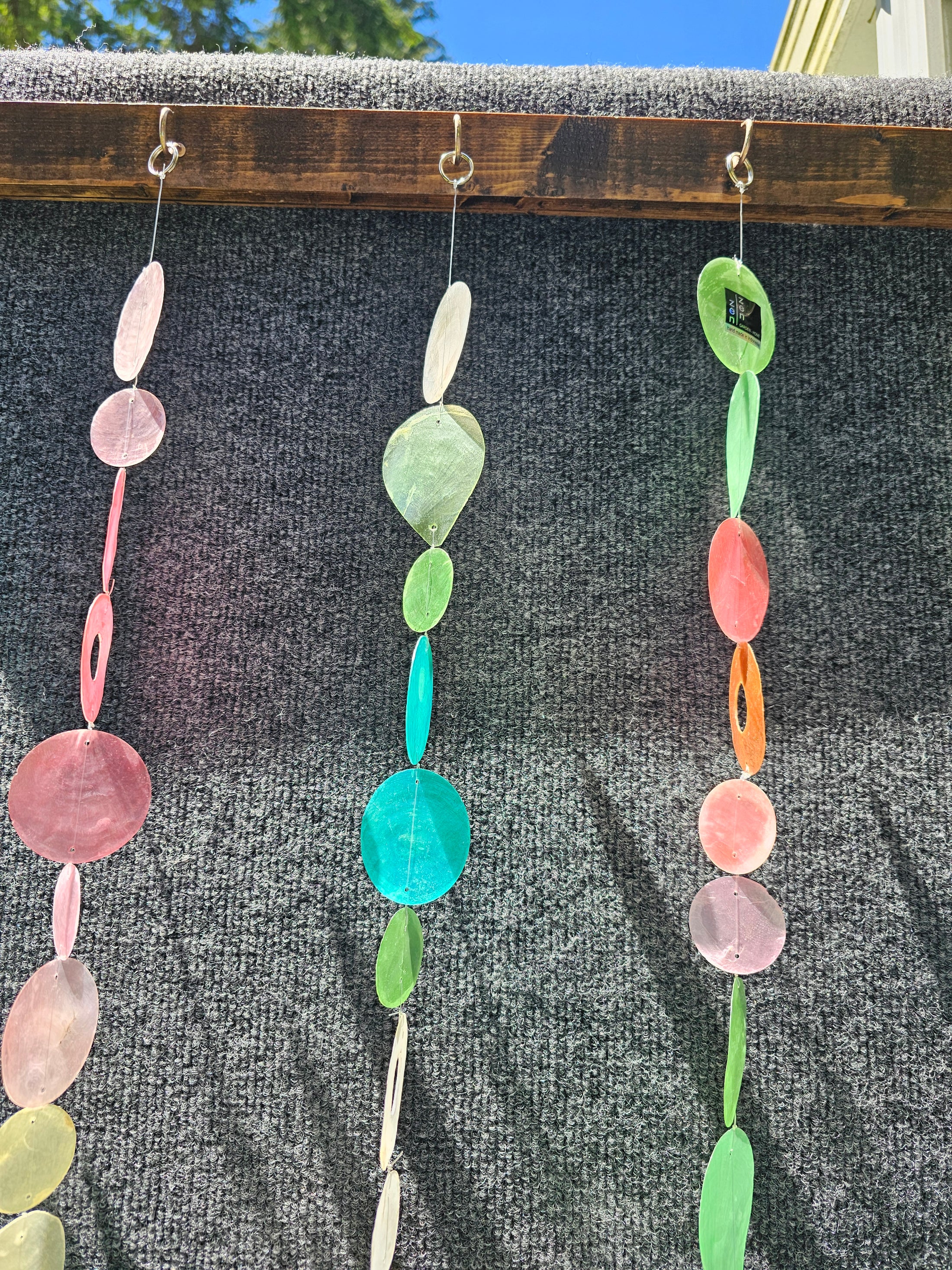 Capiz Shell Strands in Pinks and Greens 72 Inches Bougainvillea featuring a variety of pastel colored capiz shells suspended decoratively on hooks, perfect for enhancing indoor or outdoor spaces.