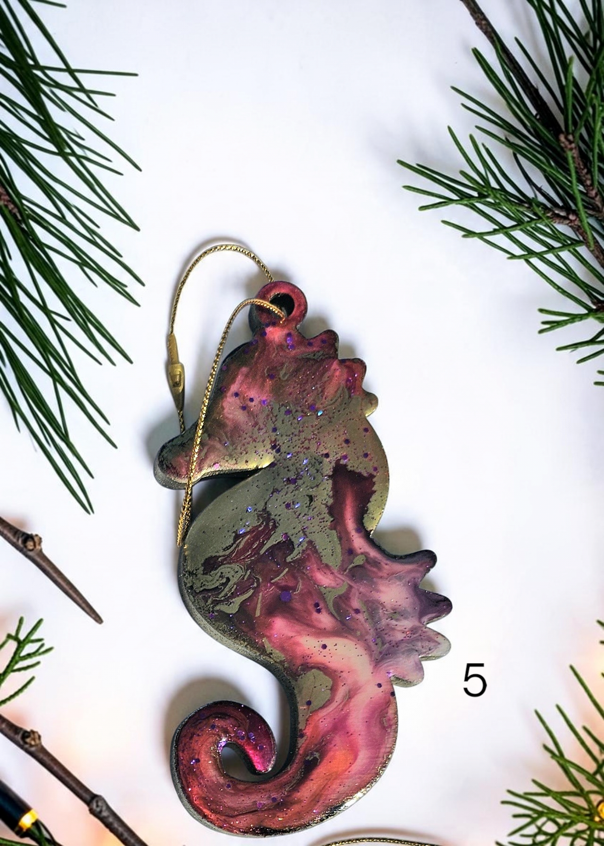 red handmade seahorse ornament with Christmas boughs and lights
