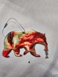 Load image into Gallery viewer, Handmade Grizzly Bear Christmas Ornament with Salmon on a wooden table, highlighting its unique craftsmanship for festive celebrations.
