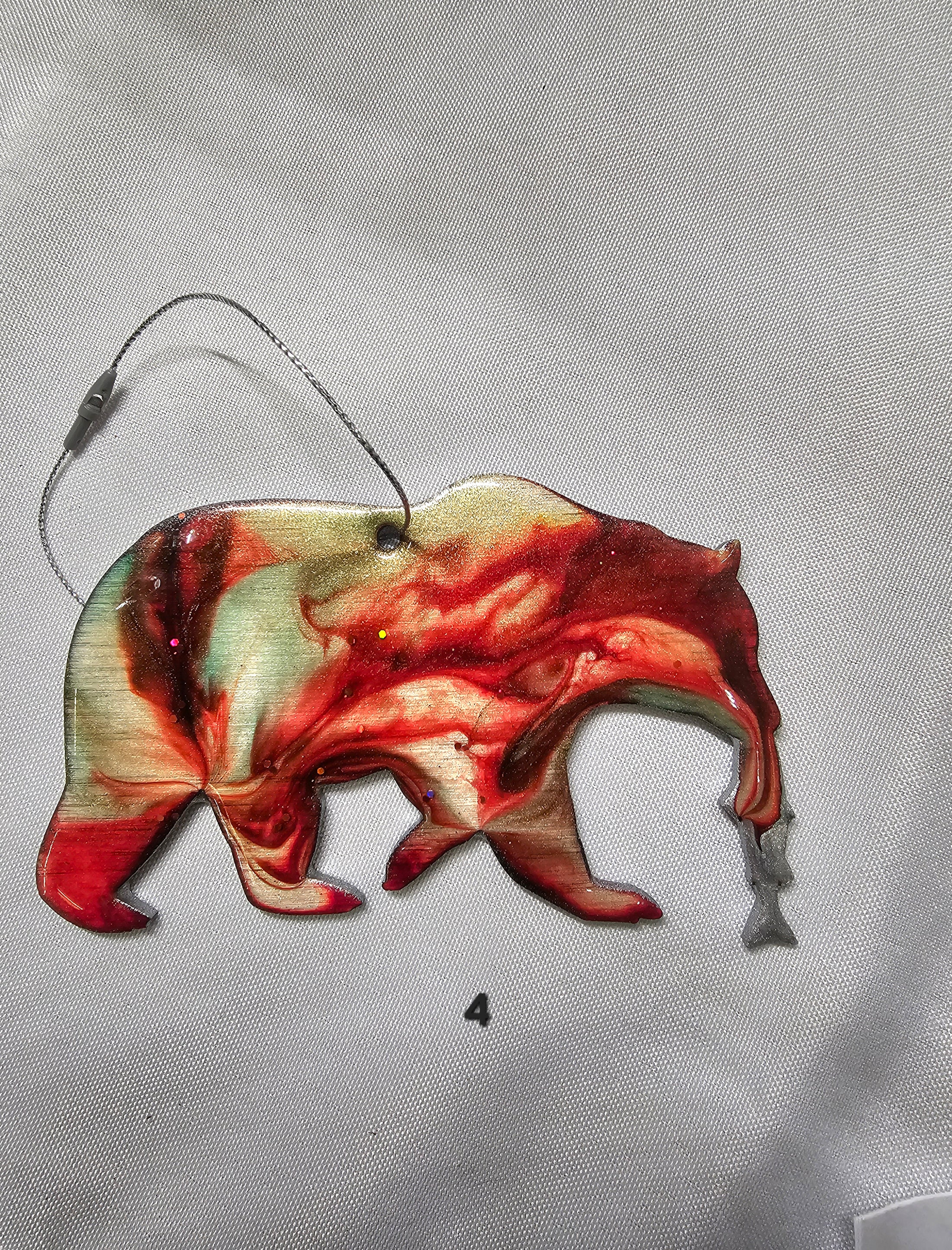 Handmade Grizzly Bear Christmas Ornament with Salmon on a wooden table, highlighting its unique craftsmanship for festive celebrations.