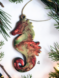 Charger l'image dans la visionneuse de la galerie, Red handmade seahorse ornament with Christmas boughs and lights
