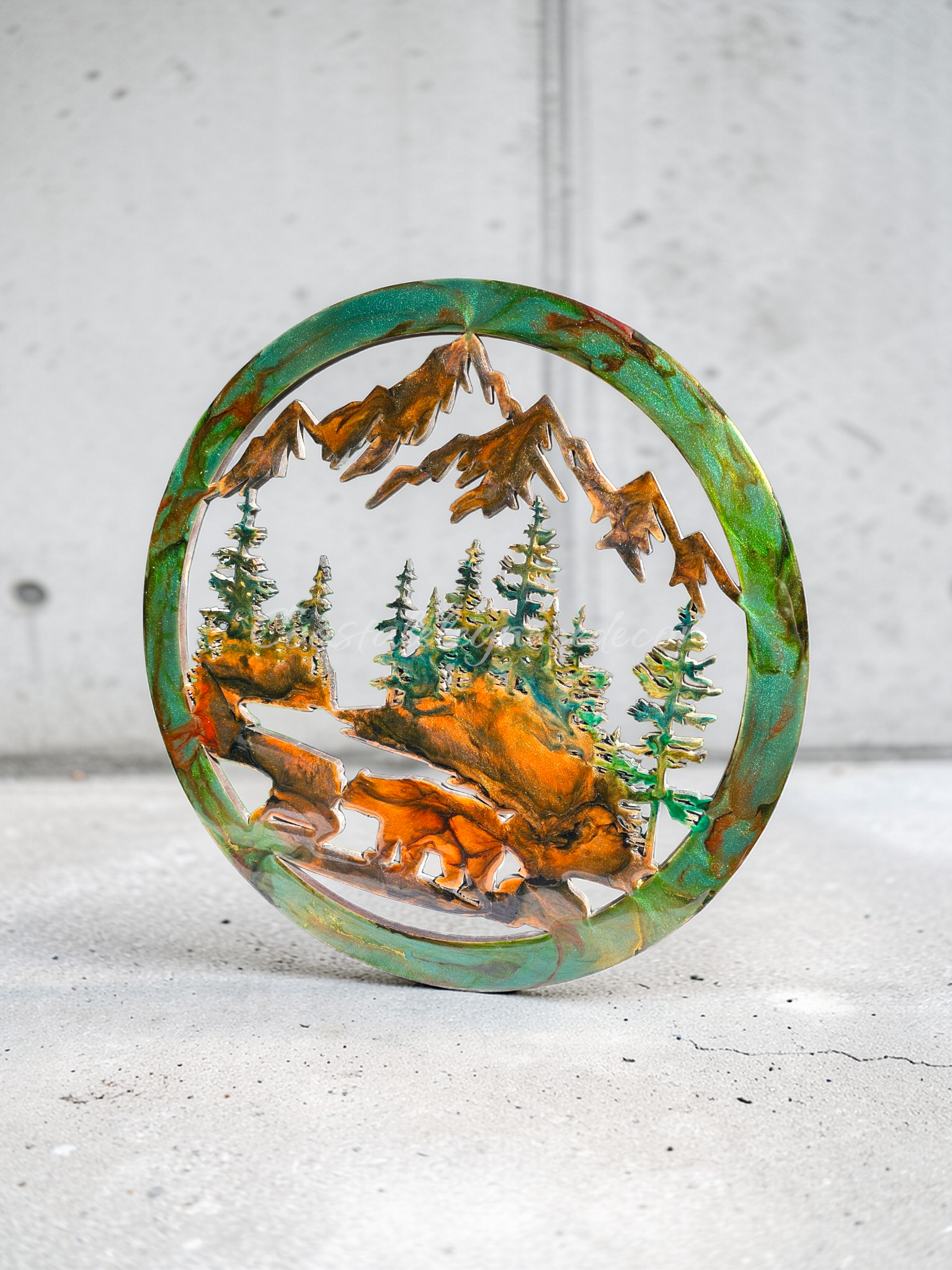 Handmade 15.5-inch resin on wood wall art side view featuring a bear at the water with fir trees and mountains, metallic accents, rustic nature-inspired décor.