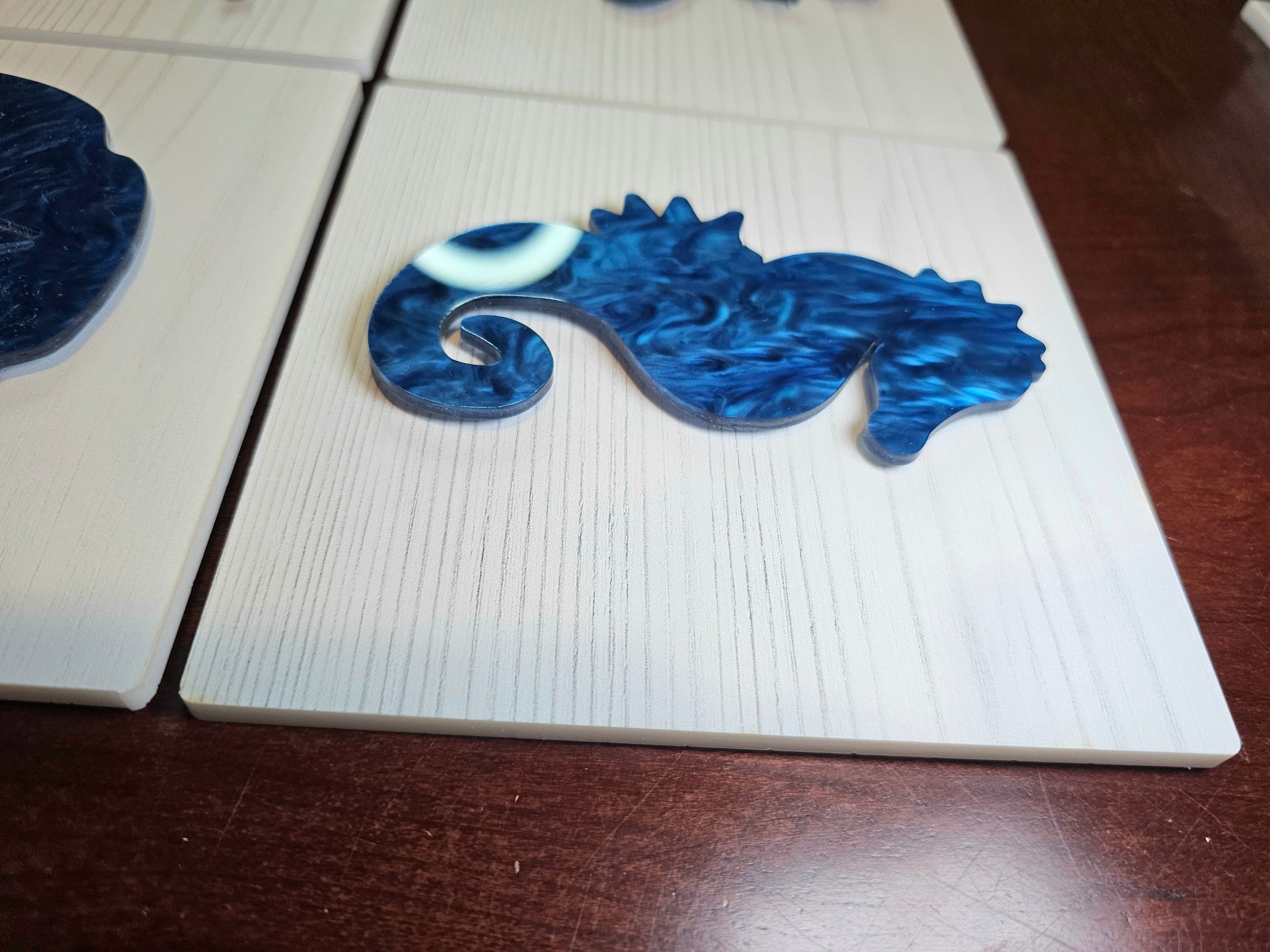 Blue seahorse-shaped object on a white surface