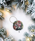 Load image into Gallery viewer, Multicolor handmade resin sand dollar ornament with gold hanger and white background.
