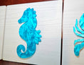 Load image into Gallery viewer, Blue seahorse design on a whitewashed background 
