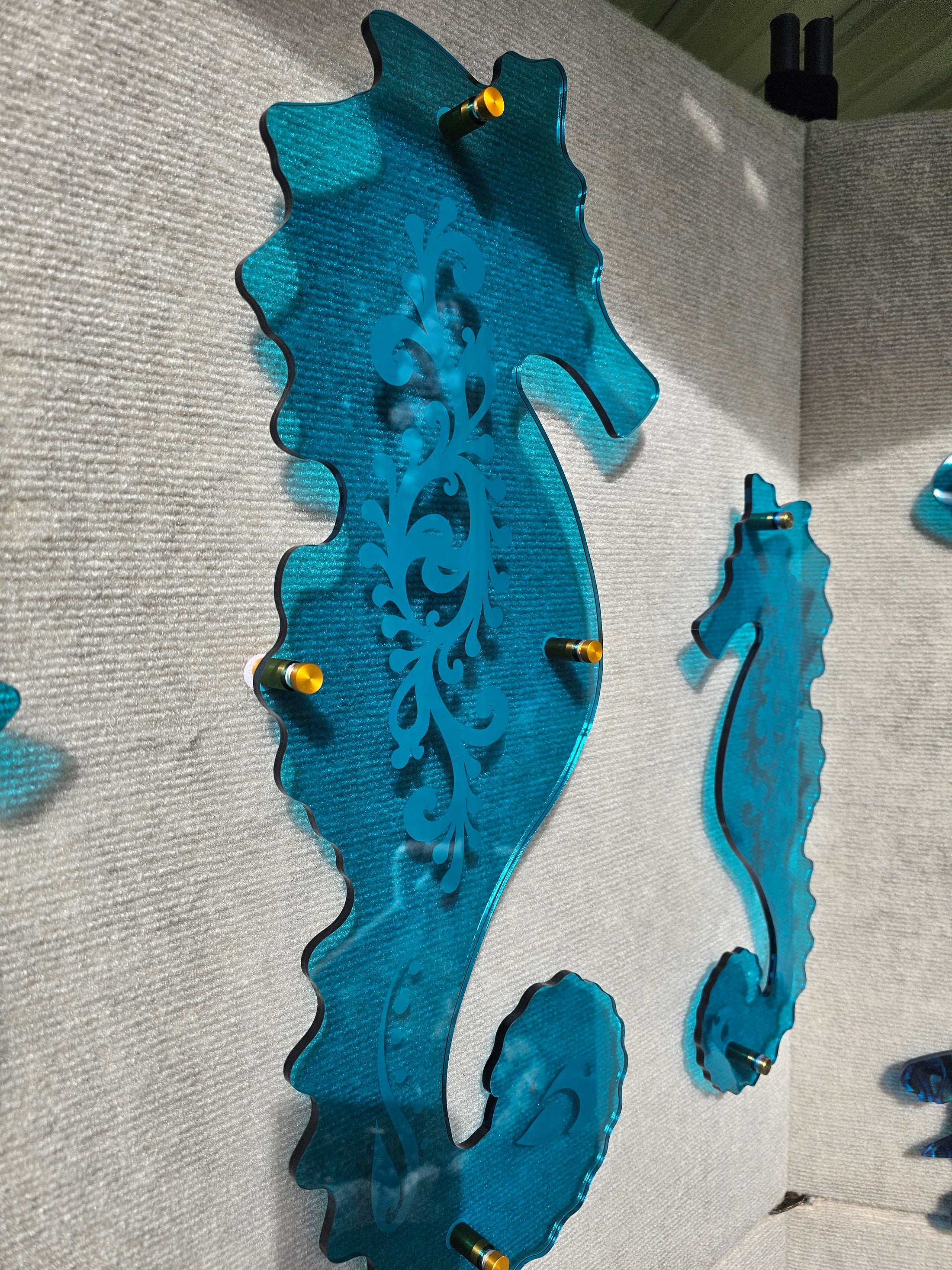 1/4 inch thick transparent teal seahorse with intricate laser-etched coral details, designed to mimic the clarity of tropical ocean water.
