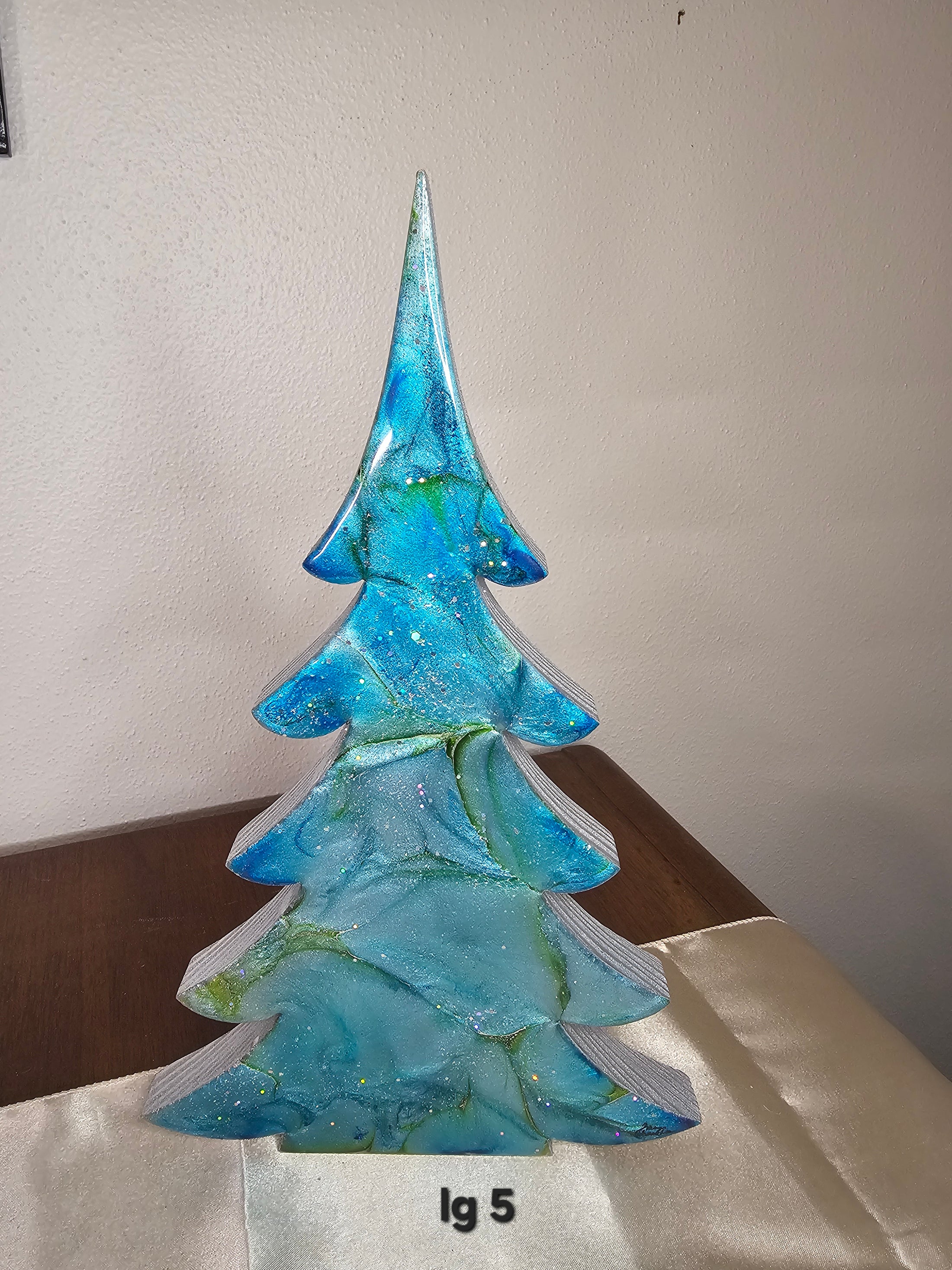 Delightful handmade blue green and silver resin Christmas trees, showcasing three sizes XL, LG, and Medium, ideal for enhancing your holiday mantelpiece.