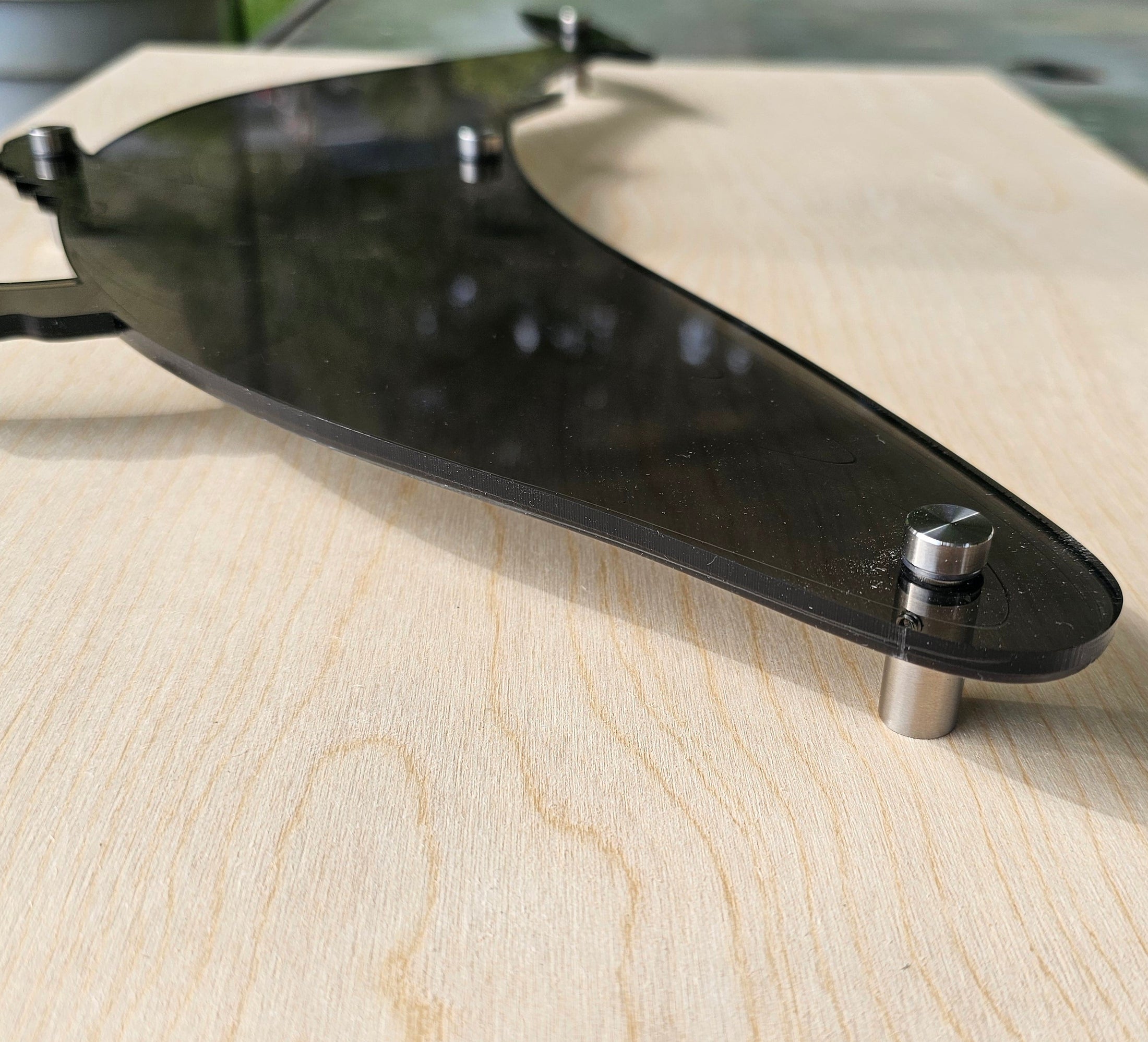 Close-up of a laser-engraved humpback whale silhouette in translucent smoke-colored acrylic, showing the polished 1/4 inch thick edges and intricate detail