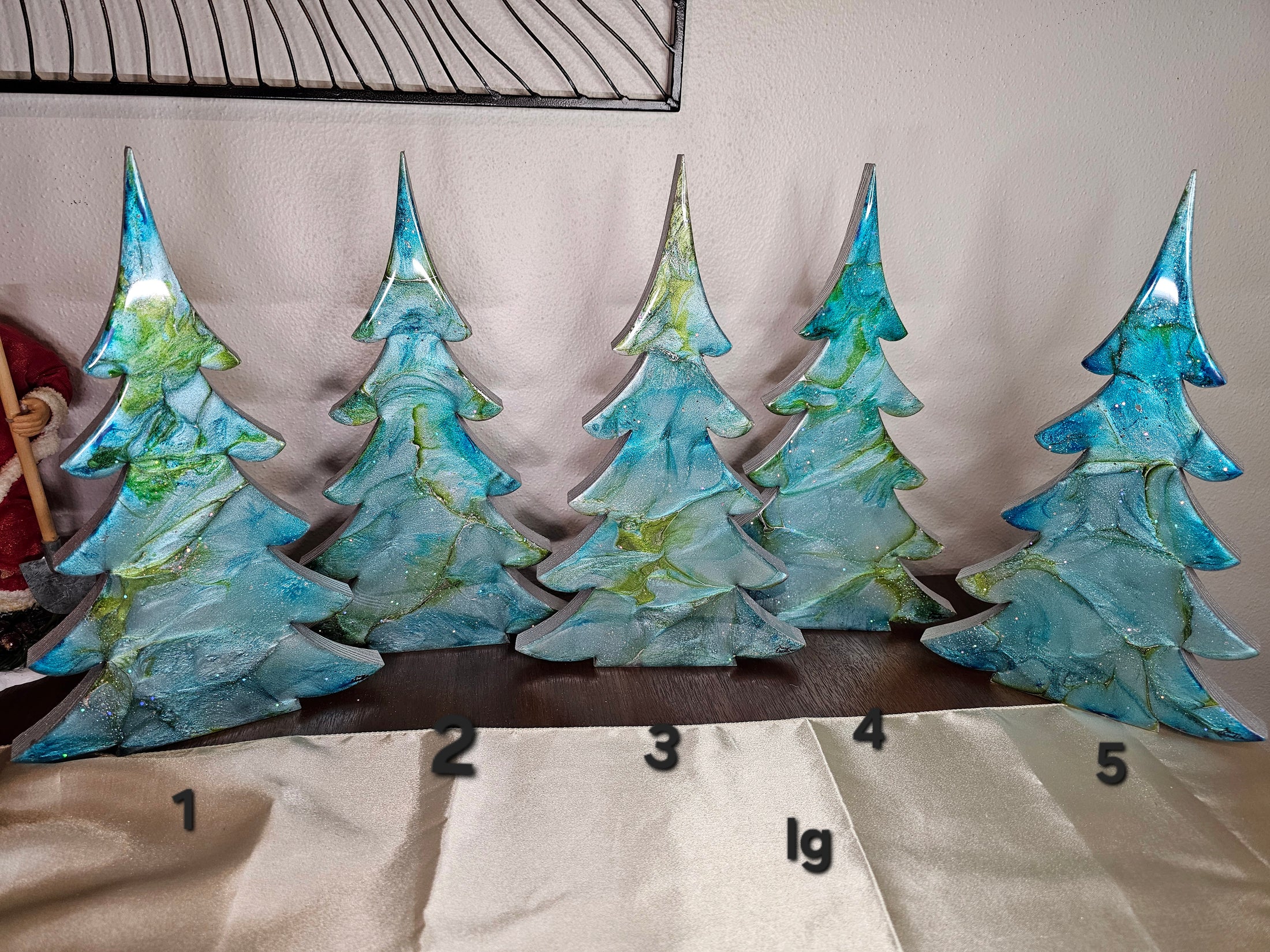 Charming handmade blue green silver resin Christmas tree, a unique addition to holiday mantelpiece decor, crafted with intricate patterns and a cheerful design.