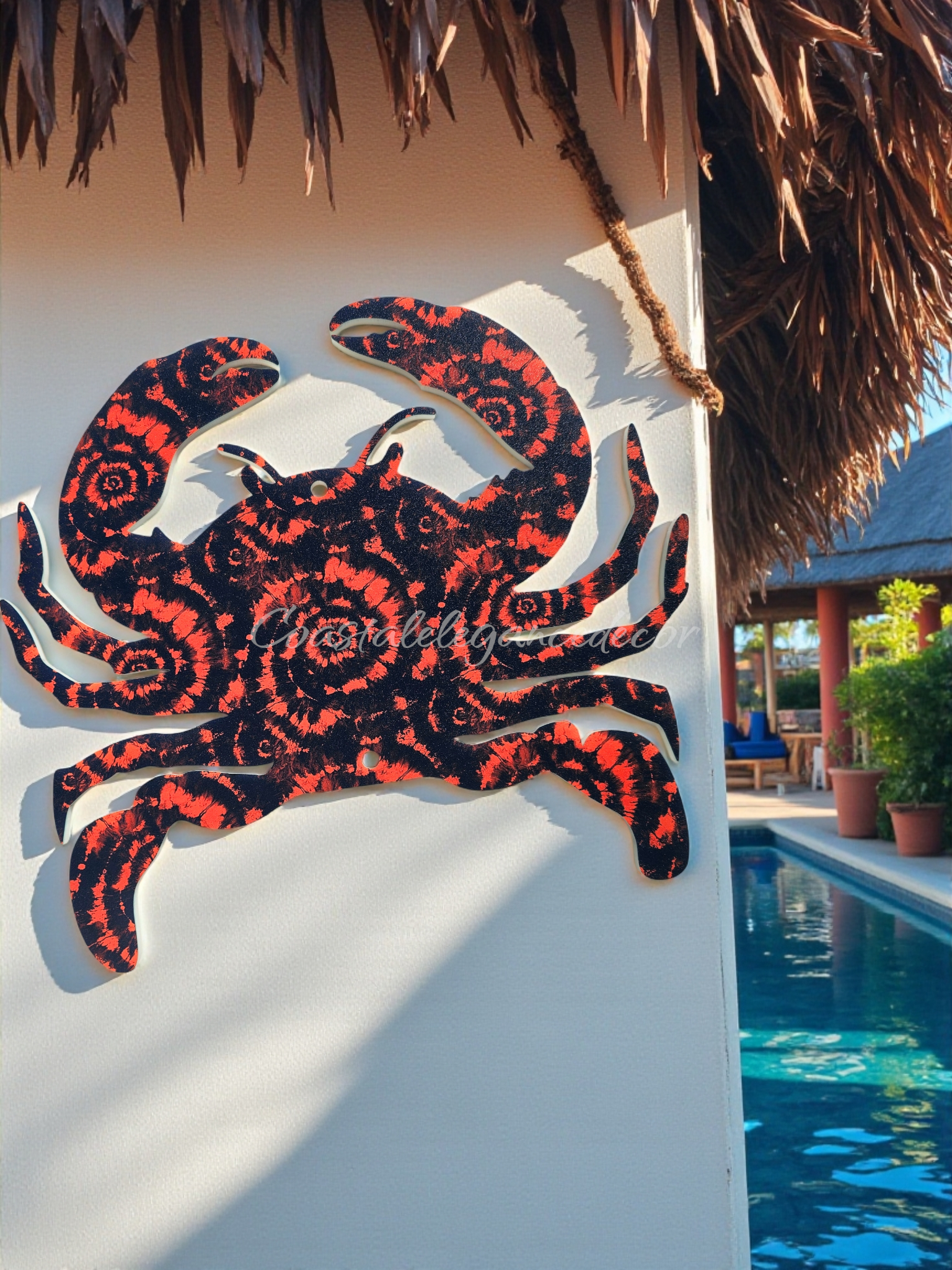 Weatherproof acrylic sea crab in patterns of orange and deep blue swirls hanging on a patio wall by the pool.