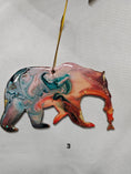 Load image into Gallery viewer, Handmade Grizzly Bear Christmas Ornament with Salmon displayed against a rustic background, perfect for holiday decor.

