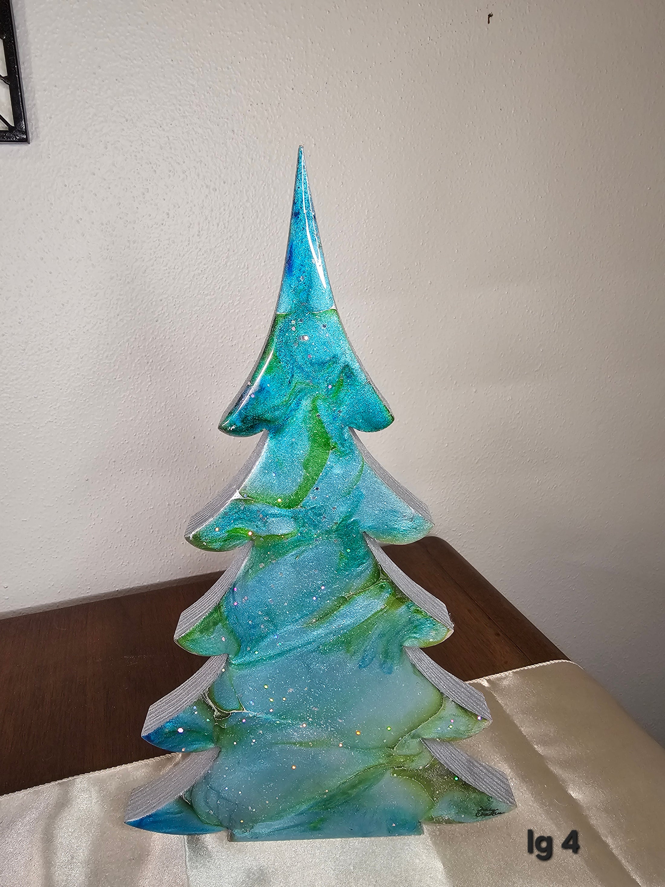 Colorful handmade blue green silver resin Christmas trees with metallic accents, adding a cheerful touch to your holiday mantelpiece décor in various sizes.