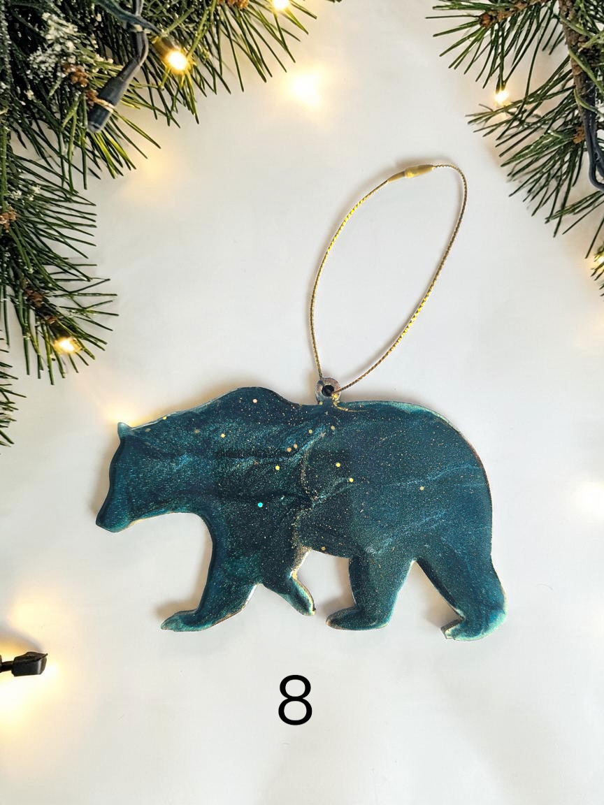 Handmade blue green resin bear Christmas ornament with white background and boughs 
