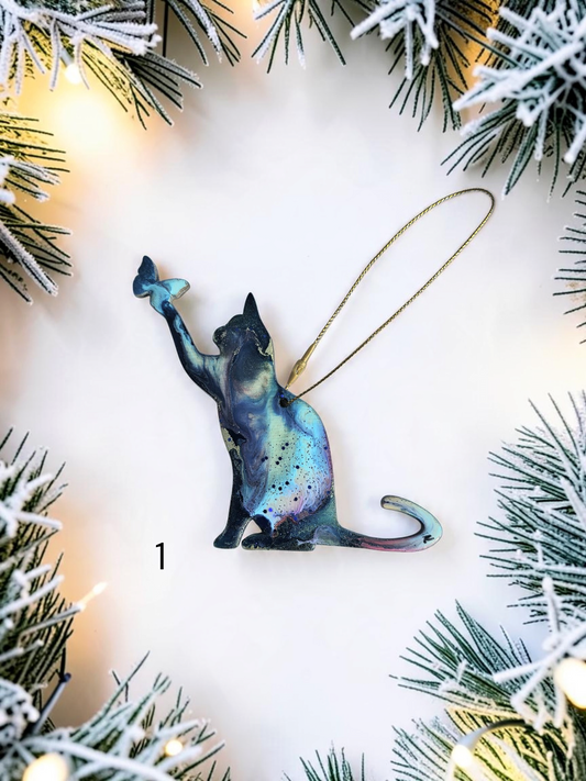 Playful cat and butterfly colorful resin handmade Christmas ornament on white background with Christmas lights 