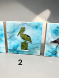 Charger l'image dans la visionneuse de la galerie, Three decorative rectangular wall art panels with blue and white marbled ink surfaces, each featuring a bird silhouette in the center. The center panel shows a mirror pelican, the right panel shows part of a shorebird, and the left panel is partially visible.
