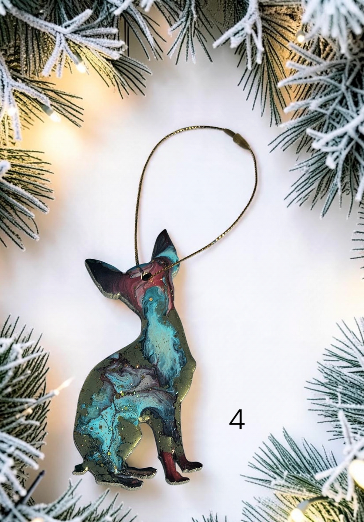Handmade sparkly blue Chihuahua dog ornament on a white background with Christmas lights 