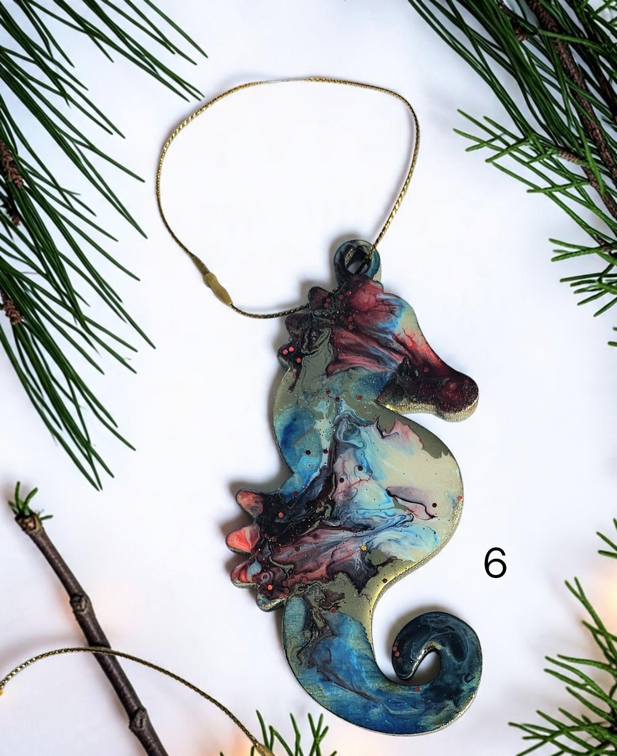 Blue handmade seahorse ornament with Christmas boughs and lights