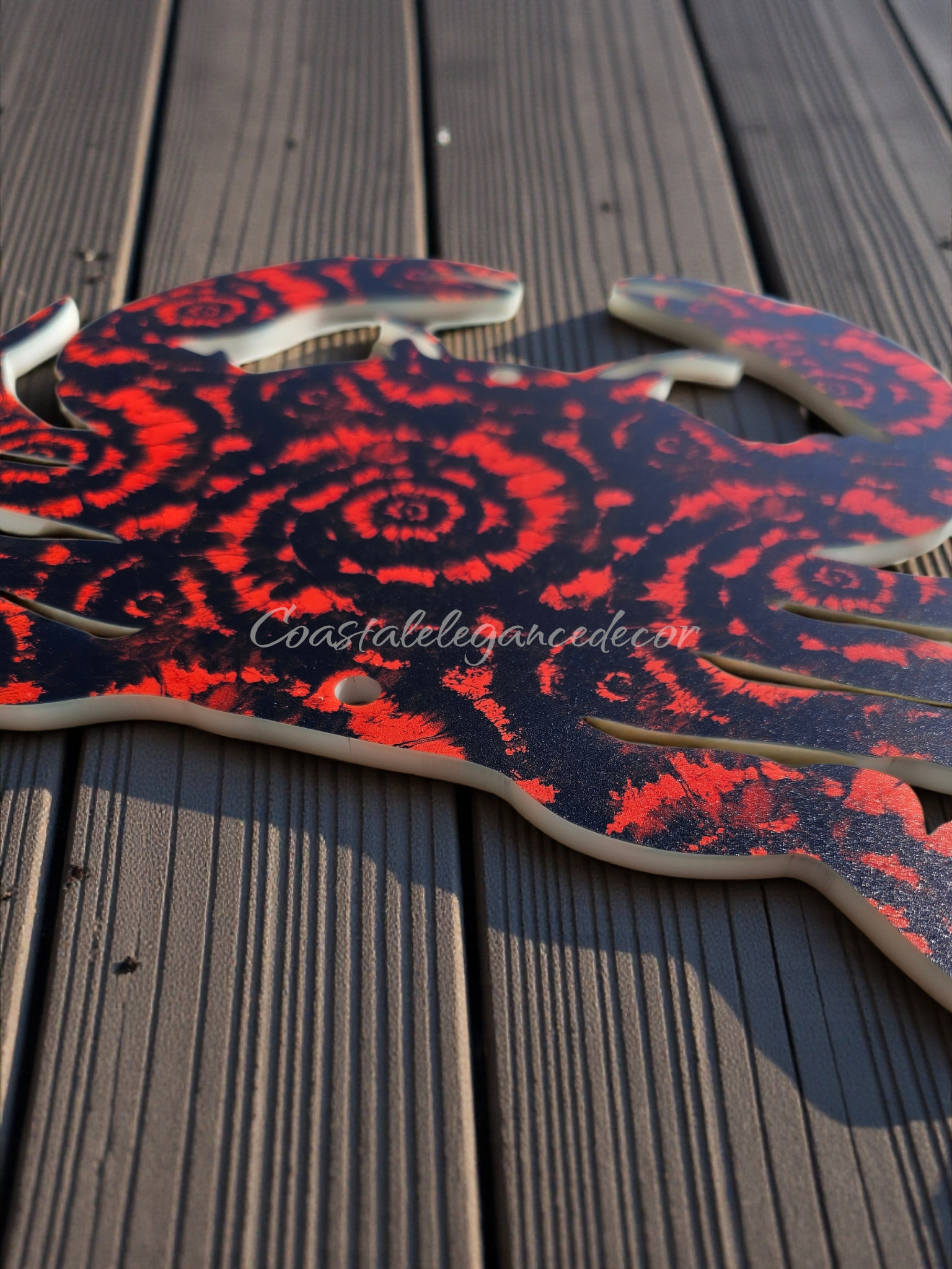 side shot of 1/4 inch acrylic outdoor crab with nail holes, lying on a deck