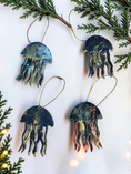 Charger l'image dans la visionneuse de la galerie, Four handmade jellyfish resin on wood Christmas ornaments with a white background with Christmas lights and boughs 
